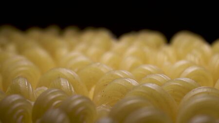 Beautiful raw pasta lies on table and camera swims smoothly over them. Black background.の写真素材