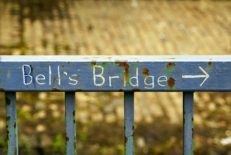 Handwritten sign on a rusty fence indicating the direction to Bell's bridge in Glasgow, Scotlandの写真素材