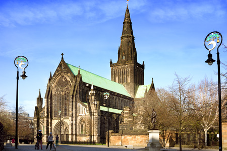 Tourists in Cathedral Square in front of the main entrance of St Mungo's Cathedral, Glasgow. Lamp-posts holding Glasgow coat of arms.のeditorial素材