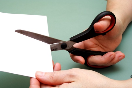 women hand is cutting paper with scissorsの写真素材