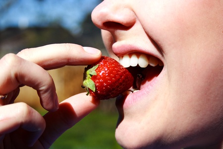 face of the beautiful woman eating a strawberryの写真素材