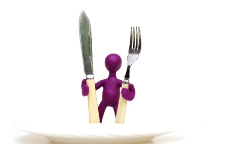 Purple man puppet of plasticine standing behind plateの写真素材