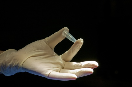 Hand covered in white glove holding the tubeの写真素材