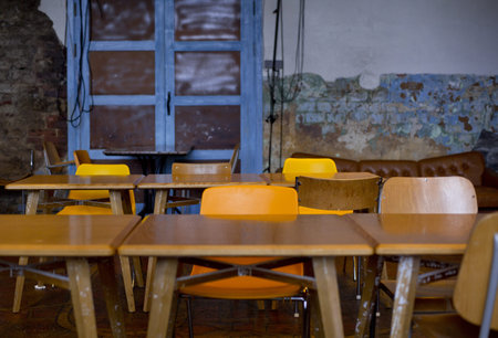 Line of old school desks stationed in room