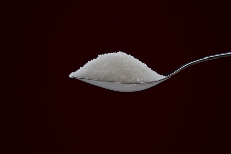 Pile of sugar on chromed spoon on backgroundの写真素材