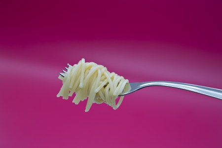 Tasty noodle on metal chromed fork on backgroundの写真素材
