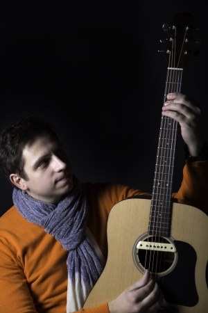 Zoomed man on background play guitar unusual way.の写真素材
