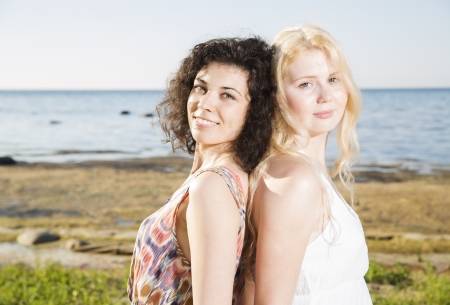 Two young womans at beach on calm silhouetteの写真素材
