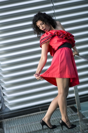 Woman in nice dress stretches her red skirtの写真素材