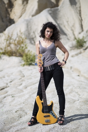 Woman placed yellow guitar on ground between legsの写真素材