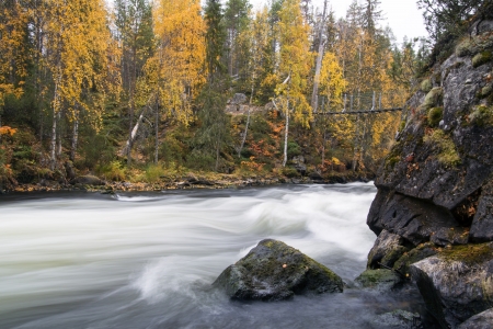 Fast flowing river flow over rocky sturdy coastの写真素材