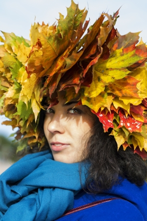 Woman with maple leaves on head look mysteriouslyの写真素材