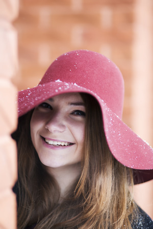Zoomed smiling woman at day near brick wallの写真素材