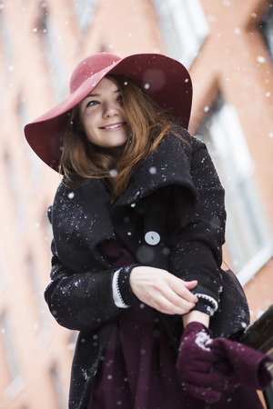 Smiling woman at winter street with vast hatの写真素材