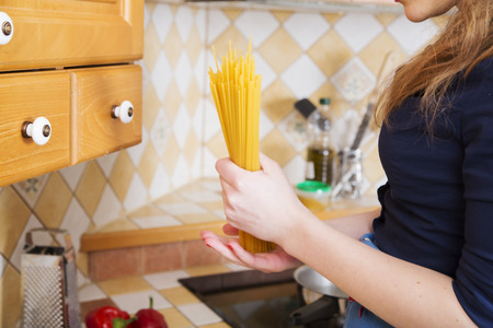 Woman hold pack of unboiled noodles and thinkingの写真素材