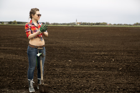 Young woman with sharp shovel and dark sunglassesの写真素材