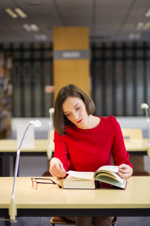 Young woman in library read book for reasonの写真素材