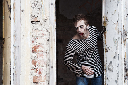 Bleeding zombie hiding behind the creepy wallの写真素材