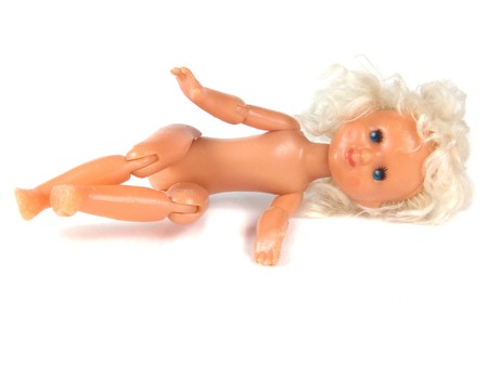 old-time, denuded doll rests upon white backgroundの写真素材