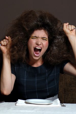 Screaming model with messed hair sitting の写真素材