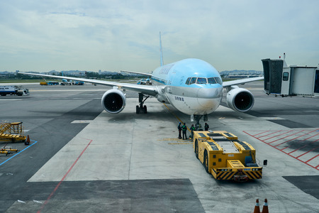 Kimpo Airport, South Korea - September 13, 2018 : A view of several airport engineers gathered underneath an airplane during preparation.のeditorial素材
