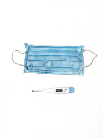 Medical mask and thermometer in the white backgroundの写真素材