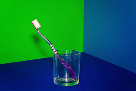 Toothbrush in a glass on a colored backgroundの写真素材