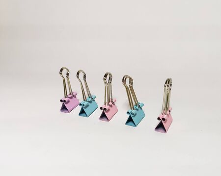 Blue and pink paper clip on a white background. Office stationery. Image with selective focus.の写真素材