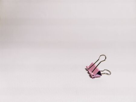 Pink paper clip on a white background. Office stationery. Space for your text.の写真素材