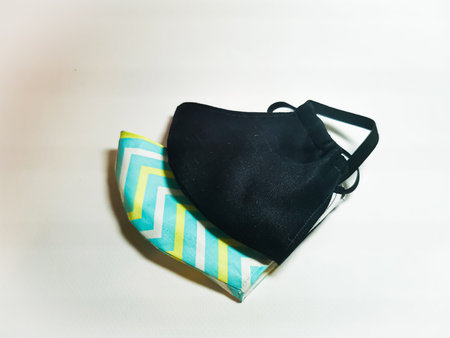 Two individual protective fabric masks. One is black, the other is in pastel colors. Male and female...