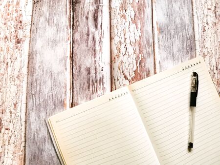 Background or desktop wallpaper: notebook in a ruler and pen on background with aged wooden boards. Space for your text.の写真素材