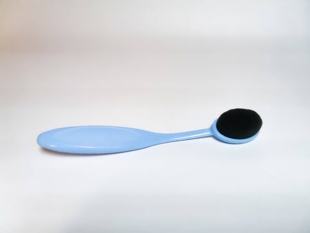 Blue brush for washing face and makeup with soft bristles on a white background.の写真素材