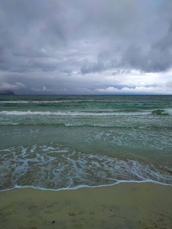 Vertical background with sea view on an evening cloudy day. Waves, sky and horizon.の写真素材