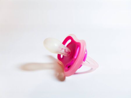 Pink pacifier on a white background.の写真素材