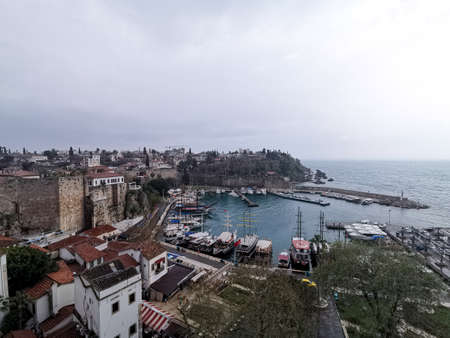 Top view of the old city of Antalya, the roofs of the houses and the port with yachts. Photo taken on a cloudy rainy day.のeditorial素材