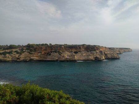 Landscape with deep blue sea and cliff on the island of Mallorca, Spain. No people. Overcast sky. Traveling concept background.の写真素材