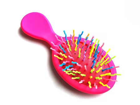 Children's bright pink hair brush or massage comb on a white background. Children's accessory for hair care and games.の写真素材