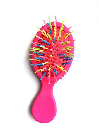 Children's bright pink hair brush or massage comb on a white background. Children's accessory for hair care and games.の写真素材
