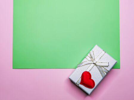 Green and pink background with a gift box and a heart with space for text. Template for greeting card, background for birthday invitations, Valentine's Day greetings, holiday symbolの写真素材