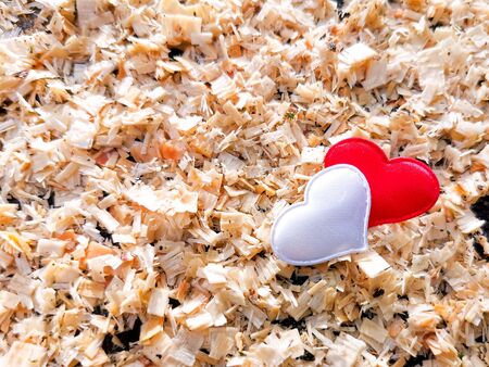 Closeup of red and white hearts against the background of wooden sawdust in sunny color. Ð¡ard for romantic greetings, background for lovers. The concept of love and relationships. Selective focus.の写真素材