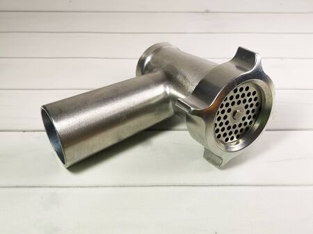 Close-up of a meat grinder on a background of light wooden boards. Meat grinder assembly. Kitchen utensils.の写真素材