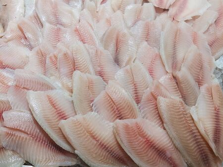 Fresh fish counter at the market. Closeup cod fillet on ice on a market counter. Useful products for the nutrition of the whole family, fish diet, balanced diet.の写真素材