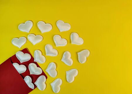 White hearts fly out of a red envelope on a yellow background. Symbol of romantic declaration of love, marriage proposal, love letter. Blank for design, text space, template.の写真素材