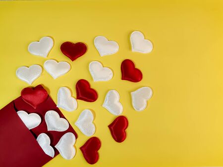 From a red envelope, white and red hearts fly out on a yellow background. Symbol of romantic declaration of love, marriage proposal, love letter. Blank for design, text space, template.の写真素材