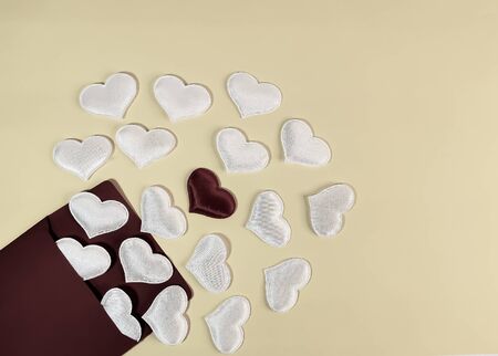 White hearts fly out of the burgundy envelope and in the center there is one burgundy heart on a pale yellow background. Symbol of romantic declaration of love, marriage proposal, love letter. Blank for design, text space, template.の写真素材