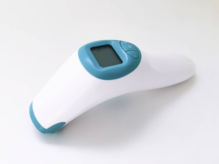 White electronic non-contact thermometer for measuring body temperature in children and adults on a white background. Safe, modern medical devicesの写真素材