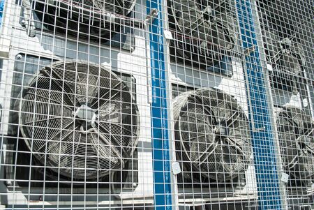 Close up of large industrial air conditioning fans behind a  protective gratings. Fans are running. Ventilation and air conditioning systems for consumer services, production and public premises.の写真素材