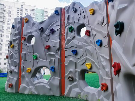 Moscow/Russia - 06/25/2020: A plastic children's wall for climbing on a playground in the courtyard of a residential quarter. Active games with children on the street.の写真素材