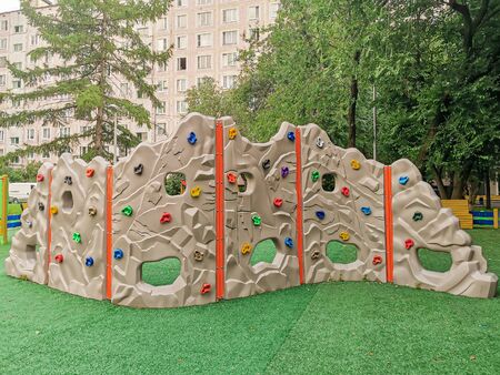 A plastic children's wall for climbing on a playground in the courtyard of a residential quarter. Active games with children on the street. Improvement of the bedroom communities of the city.の写真素材
