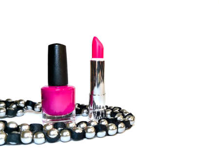 Nail polish, open bright pink lipstick and silver-black beads on a white background. Self-care, makeup. The concept of beauty industry, blank to insert text or logo.の写真素材